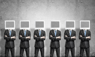Businessmen with monitors instead of head.