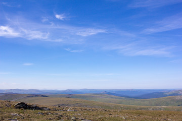 Awesome panorama for a postcard or calendar. Blue cloudy sky and mountain view in the distance. Nature of the Northern Urals.