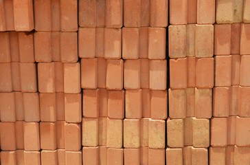 red bricks are stacked wall /pile of  orange bricks baked clay background