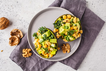 Avocado halves stuffed with avocado, nuts and chickpeas, top view.