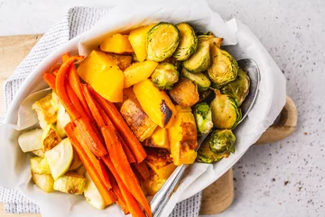 Gordijnen Baked brussels sprouts, zucchini, pumpkin and carrots on a white dish. © vaaseenaa