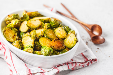 Baked brussels sprouts on a white plate.