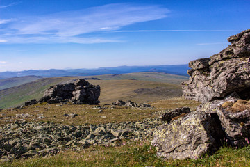 Fototapeta na wymiar Beautiful panoramic view of the Ural Mountains. Stone placer on the plateau of the Ural Mountains. Ridges and valleys against the blue sky. Nature Taiga in the wild.