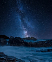 Fototapeta na wymiar Vibrant Milky Way composite image over landscape of Godrevy lighthouse on Cornwall coastline in England