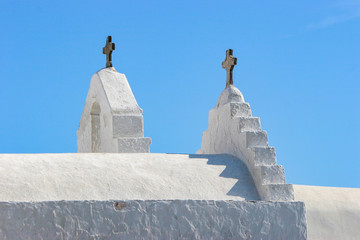 White church and cross set against the deep blue skies of Mykonos, Greece