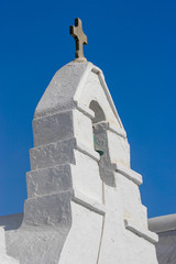 White church and cross set against the deep blue skies of Mykonos, Greece