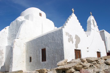 White church and cross set against the deep blue skies of Mykonos, Greece