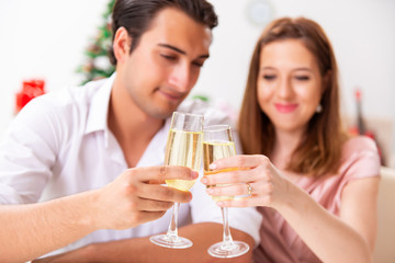 Young couple celebraring christmas with champagne