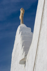 White church and cross set against the deep blue skies of Mykonos, Greece