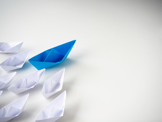 Blue paper boat leading among white ships