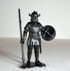 Black viking figurine with spear and shield molded plastic close up Selective Focus