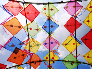 Fototapeta na wymiar Vivid Colorful Decorative Kites Against Cloudy Sky
