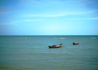Small fishing boat parked on the sea and waves