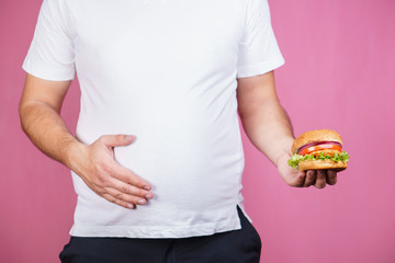 glutton man eating tasty burger. imbalanced ration, snacking with fast food, unhealthy diet