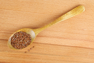 Raw flax seeds in wooden spoon