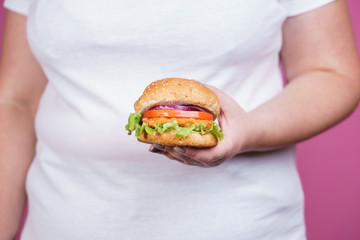 weight loss, overweight, plus size, diet, unhealthy eating. fat woman with fresh hamburger