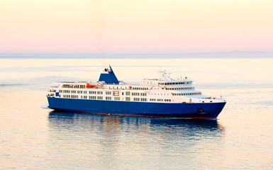 Fototapeta na wymiar Sunset and blue white ferry boat in greek islands