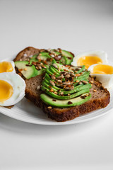 eggs, avocado on bread on white
