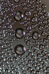 Water drops on glass against dark background