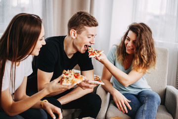 party, leisure, people eating, friendship, food delivery, conversation. cheerful friends joking eating pizza and laughing