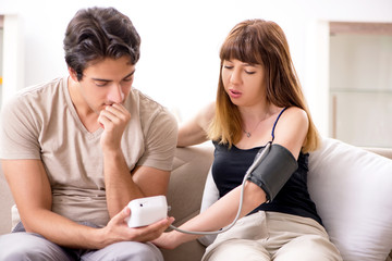 Obraz na płótnie Canvas Husband checking wife's blood pressure