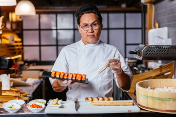 confident waiter with a plate of sushi set. close up photo
