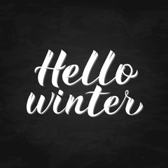 Fototapeta na wymiar Hello Winter calligraphy lettering on chalkboard background. Quote hand drawn with brush. Typography poster. Vector illustration. Easy to edit template