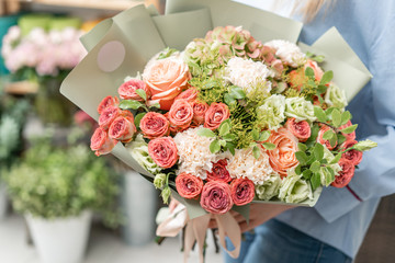 European floral shop. Bouquet of beautiful Mixed flowers in woman hand. Excellent garden flowers in the arrangement , the work of a professional florist.