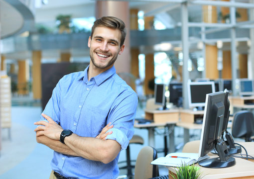 Young Man Posing Confident And Positive In Professional Workplace Office With Space.