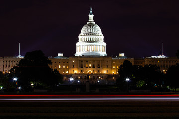 United States Capitol in Washington DC by night with a long exposure and traces of lights from the car passing by.