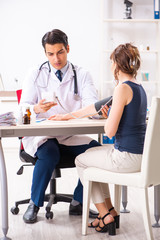 Young doctor checking woman's blood pressure