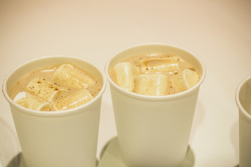 Two cups of hot cocoa and snow-white marshmallows floating in it.