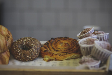 Close-up of cinnamon and raisin curl buns, fresh muffins sprinkled with powdered sugar.