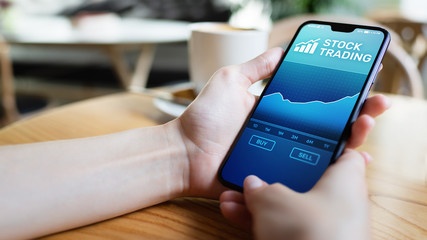 Mobile trading application with stock market chart on smartphone screen. Forex and investment business technology concept.