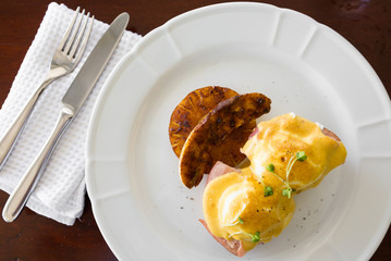 Eggs Benedict with utensils top view