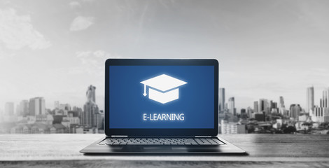 E-learning on computer laptop and city sunrise background. Online education, e-learning and e-book concept - obrazy, fototapety, plakaty
