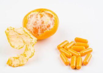 Tangerine and pills on white background close up. The concept of medicine and health.