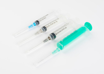 A set of disposable syringes for injections of different sizes on a white background.