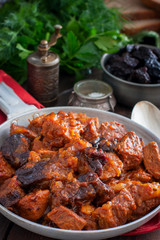 Stewed beef in tomato sauce with prunes, selective focus