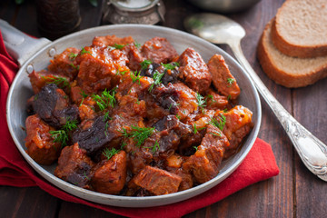 Beef with prunes in tomato sauce in a pan, horizontal