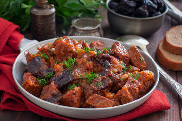 Beef with prunes in tomato sauce in a pan, horizontal