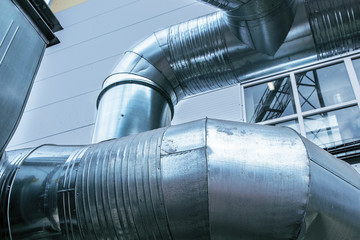 Close up view of the modern industrial building exterior with huge diameter ventilation pipes on...