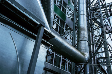 Close up view of the modern industrial building exterior with huge diameter ventilation pipes on...