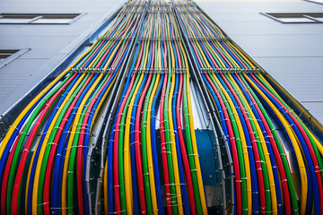 Different bright colors electric wires installed on the constructions of industrial building.