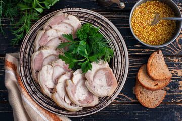 Boiled pork roll with chicken fillet and spices on a wooden table, top view, horizontal