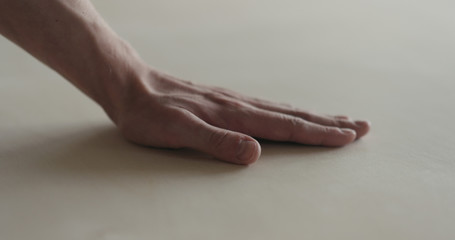 closeup man hand touches plywood to check surface