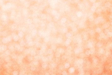 Blurred abstract background with peach glittering summer lights.
