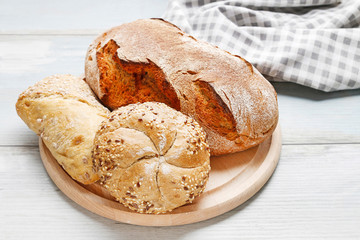 Buns, rolls and bread on wooden table