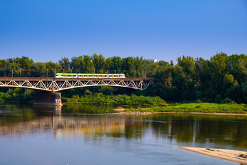 Warsaw, Poland - Panoramic view of the Vistula river with Most Srednicowy railway bridge and wooded Praga district of Warsaw - obrazy, fototapety, plakaty