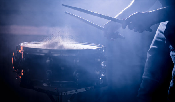man playing the snare drum on a beautiful colored background